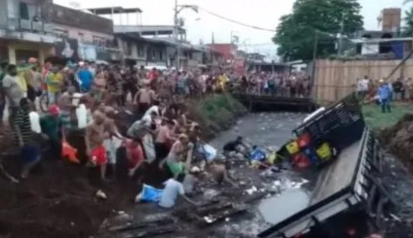 Caminhão de cerveja tomba em esgoto e população mergulha para pegar mercadoria