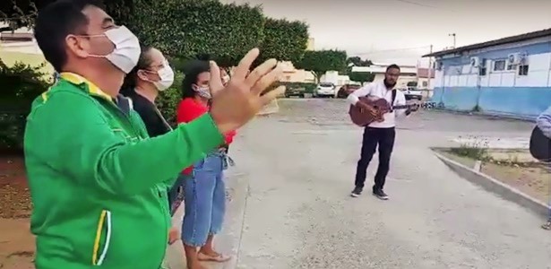 Distantes e utilizando máscaras, pastores e fiéis se reúnem para orar em frente à hospital de Uauá