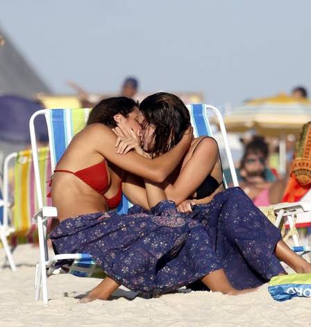 Atriz da Globo beija a namorada em praia, vê flagra e se esconde sob cabaninha